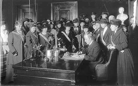 Governor Edwin P. Morrow signs the ratification as members of the Kentucky Equal Rights Association look on.