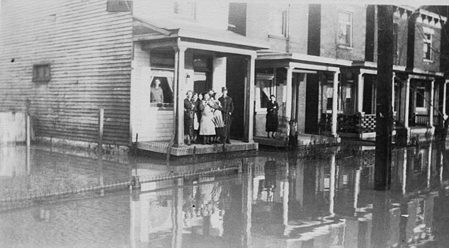 Family on porch at Fourth and Saratoga streets during a flood, Newport, Kentucky, ca. 1937.