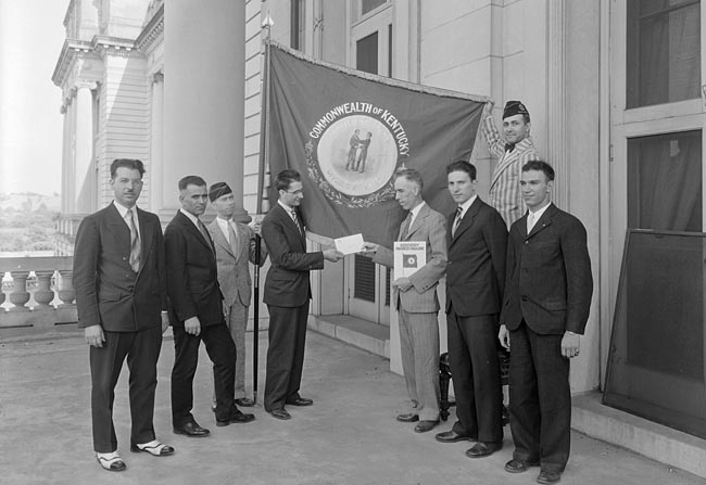 C. Frank Dunn of the Kentucky Progress Commission presents Kentucky's official flag to a guard of honor from Greece, 1930.